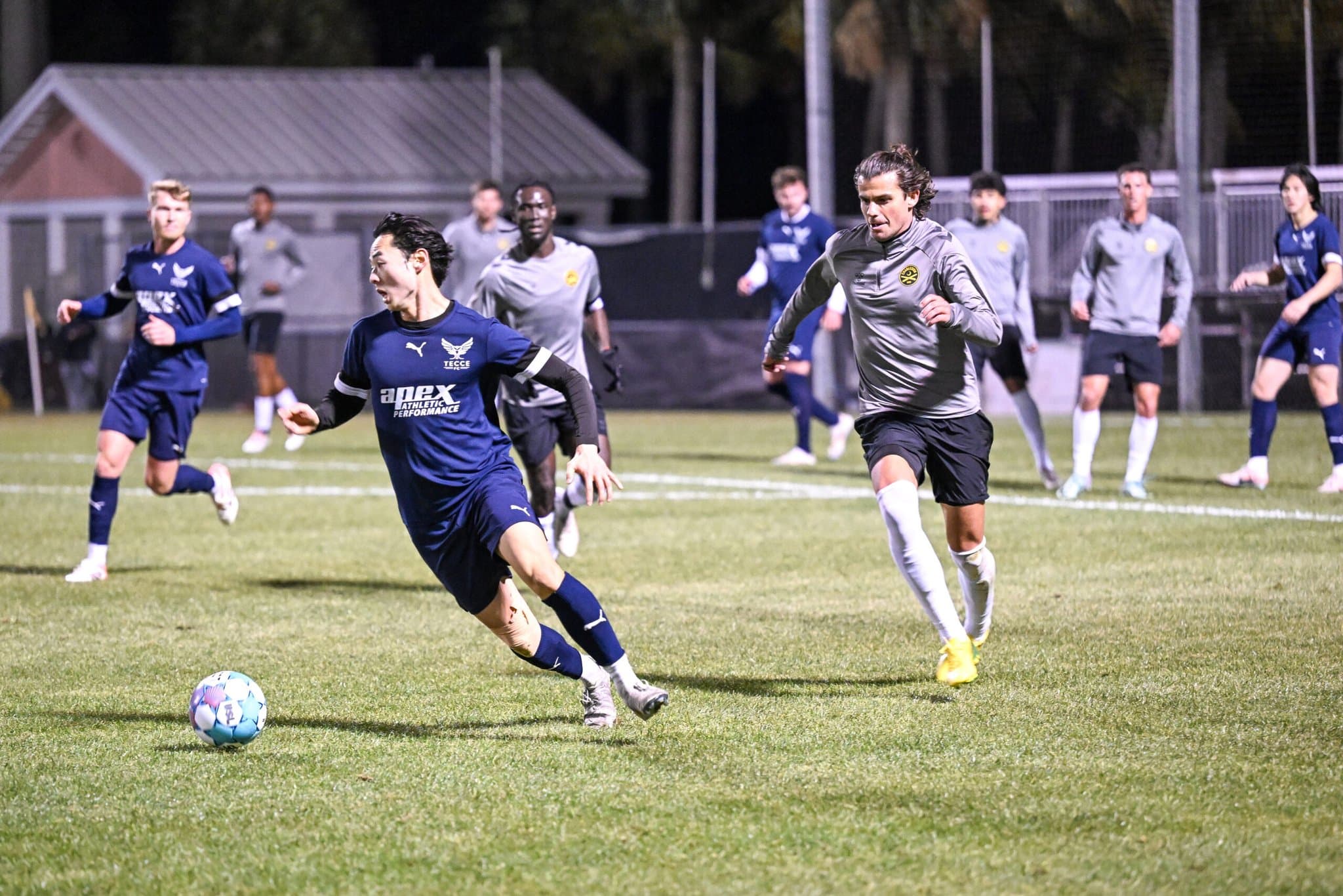TECCE footballers competing in a match under the lights